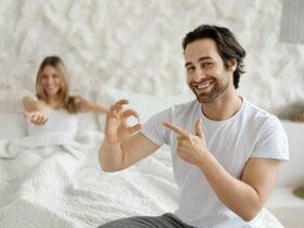 Mens health and sexual problems, male power and libido. Happy man holding pill and pointing on it