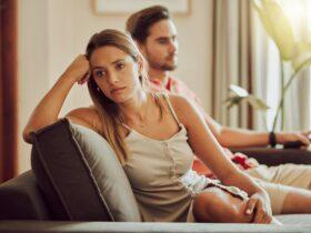 Unhappy, sad and annoyed couple after a fight and are angry at each other while sitting on a couch